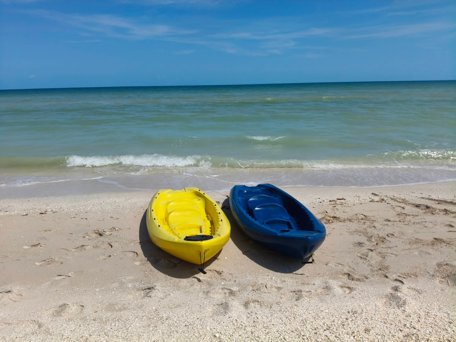 Kayaks amarillo y azul en la orilla de la playa de Sisal